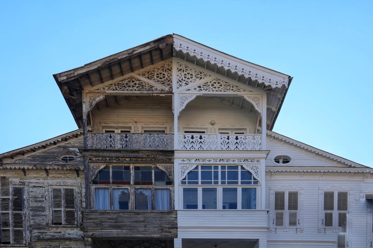 A detailed view of a half-renovated wooden house facade, showing old vs new.